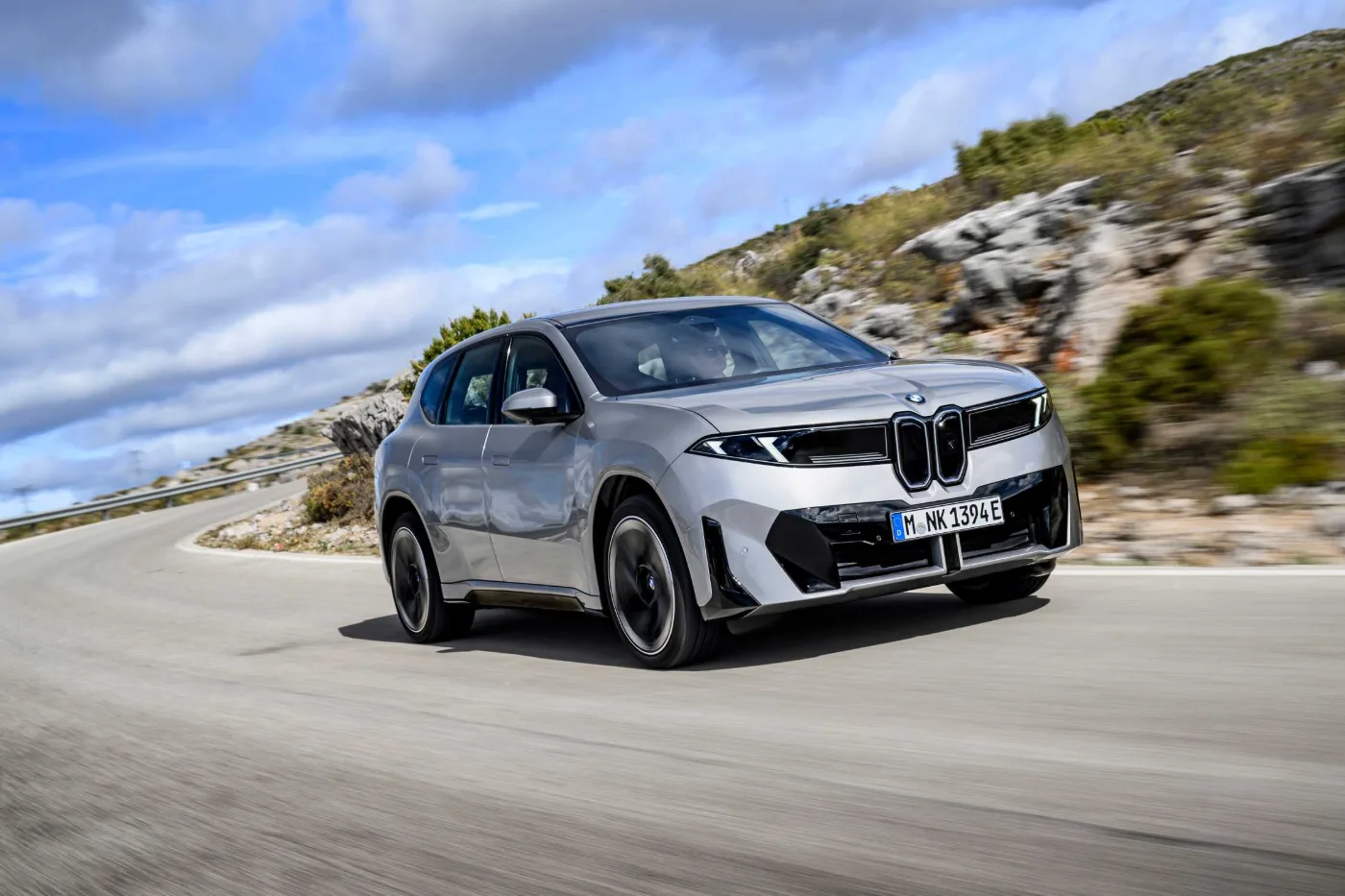 BMW iX3 Space Silver, in Fahrt auf einer Küstenstraße