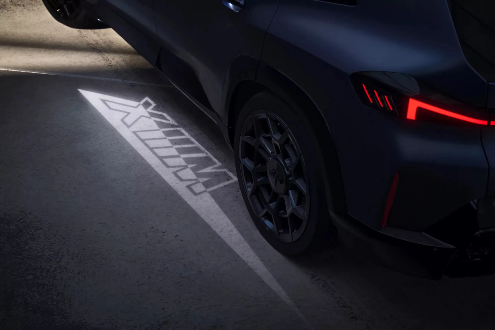 BMW XM v noci s uvítacím světelným kobercem